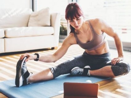Pessoa a praticar exercício dentro de casa.